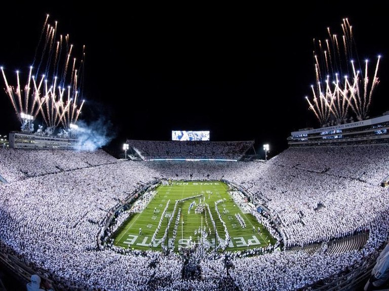 Wide overview shot of Beaver Stadium packed with fans before the start of a night game with fireworks and fanfare on the field